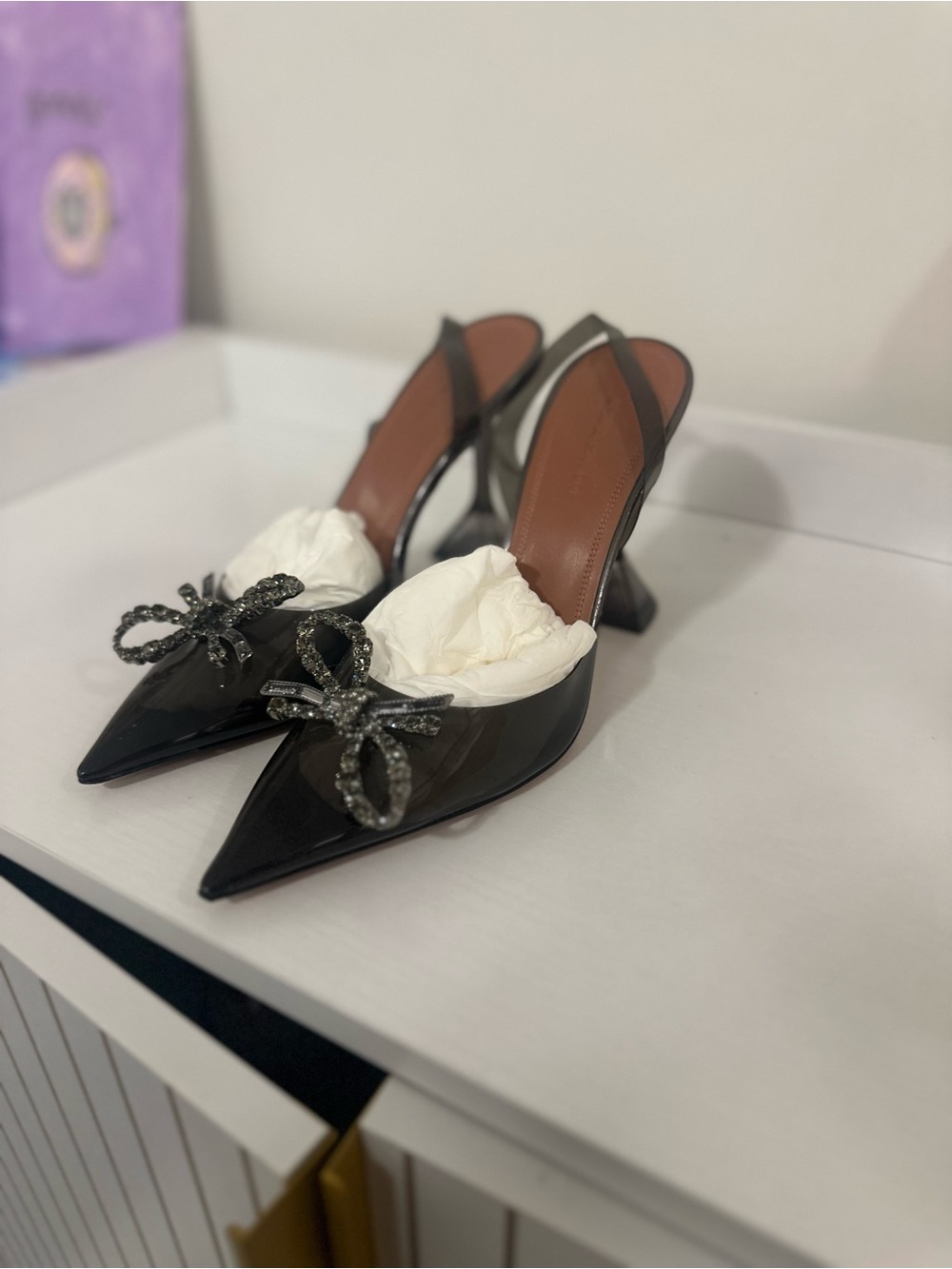 Amina Muaddi Black Patent Pointed-Toe Slingback Heels with Crystal Bow